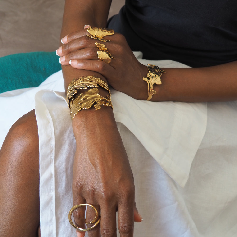 woman wearing multiple pieces of gold Lotta Djossou Jewelry