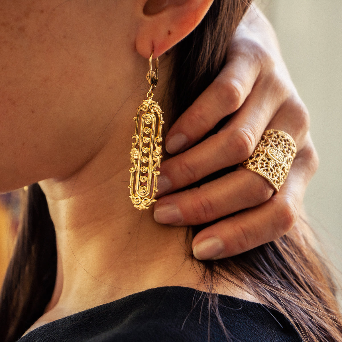 Woman wearing Gold Lisa earrings and Gold Lace ring from Lotta Djossou Paris