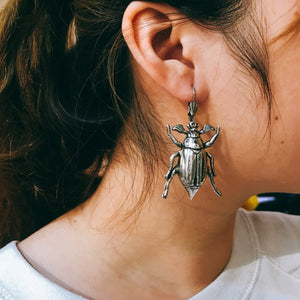 
                  
                    Girl wearing silver cockchafer earrings
                  
                