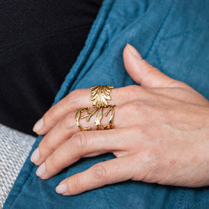 
                  
                    Woman wearing two Lotta Djossou gold rings
                  
                